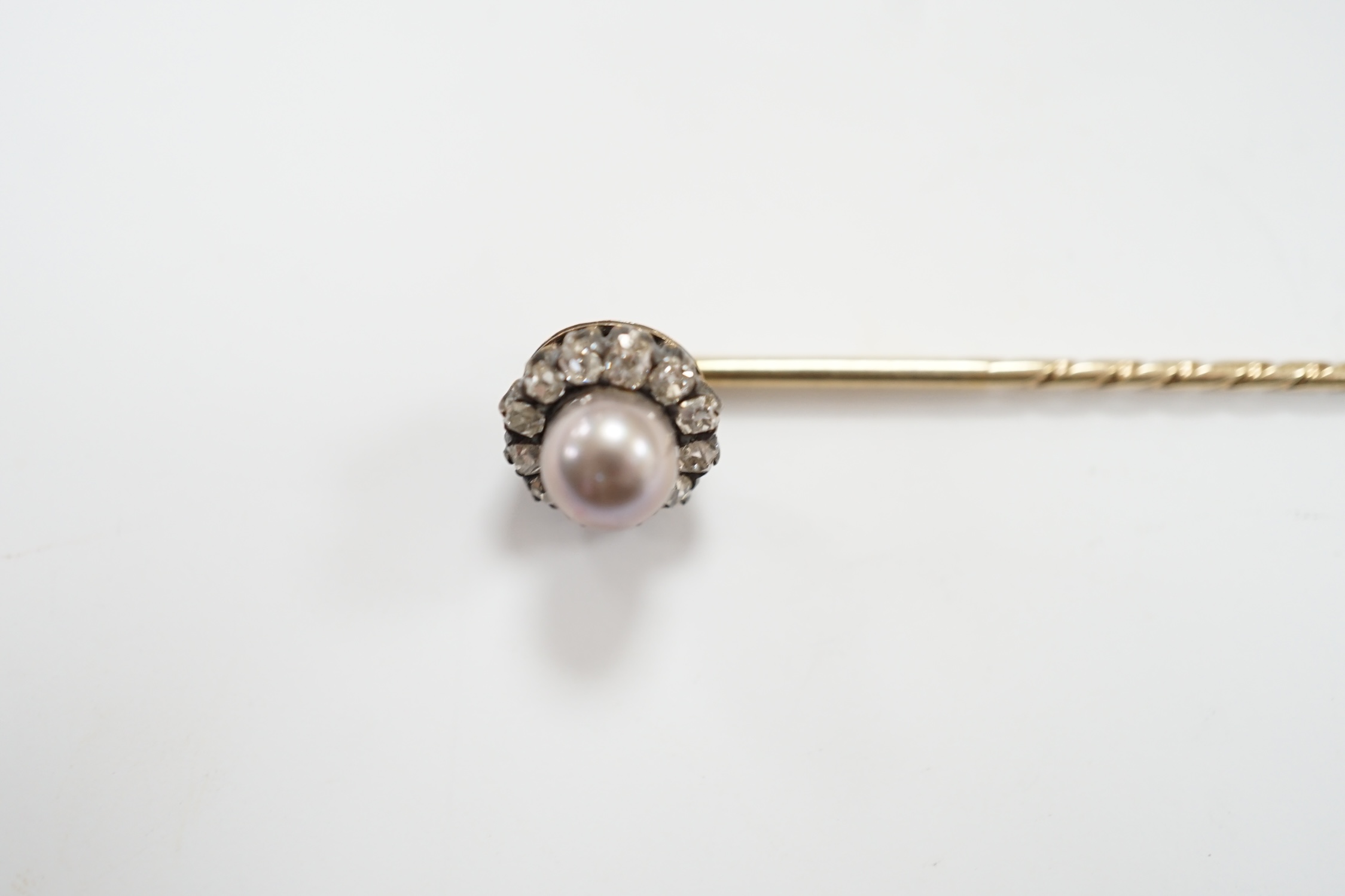 An early 20th century yellow metal, cultured pearl and old cut diamond cluster set stick pin, 70mm, gross weight 2.8 grams.